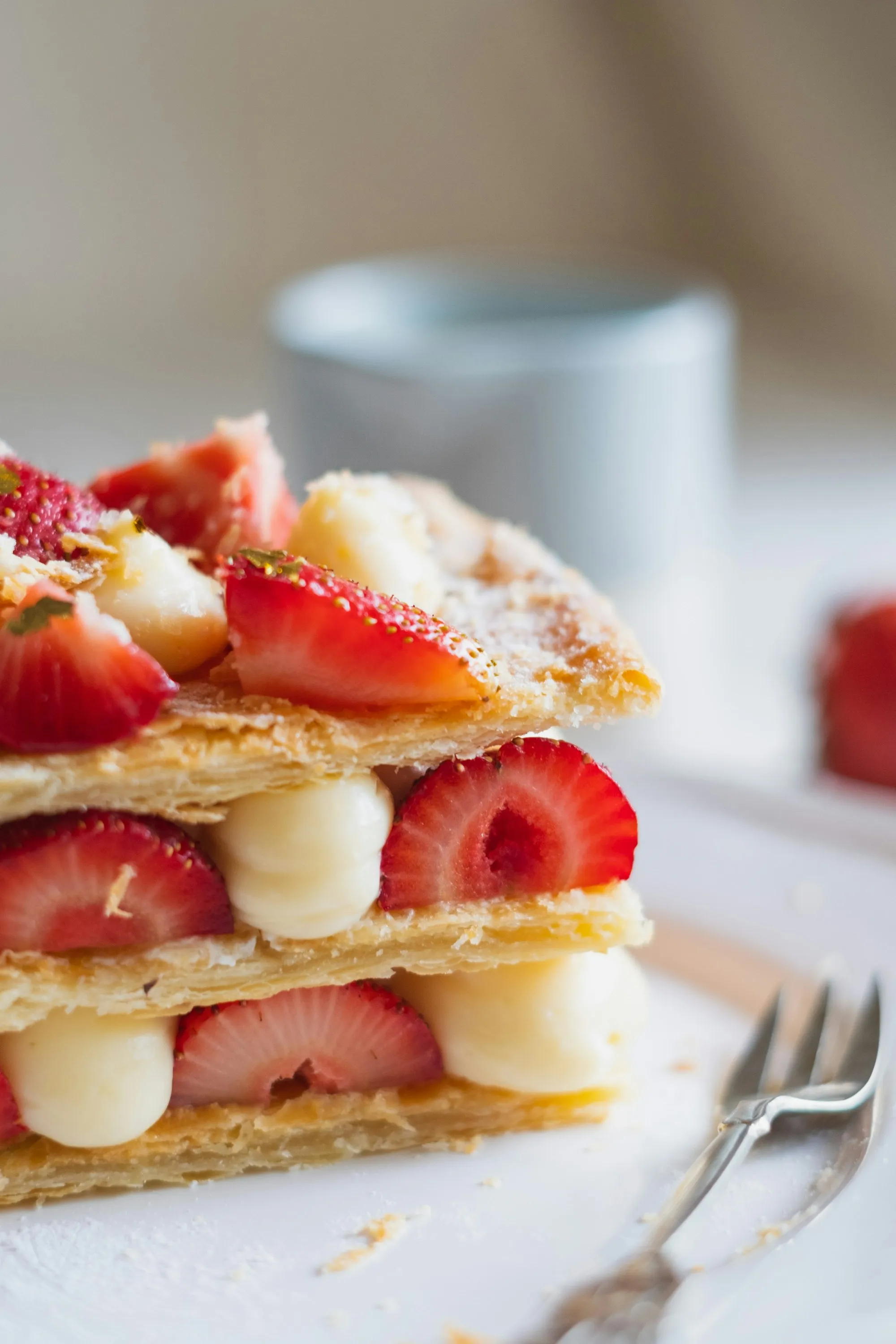 A layered mille-feuille filled with cream and halved strawberries